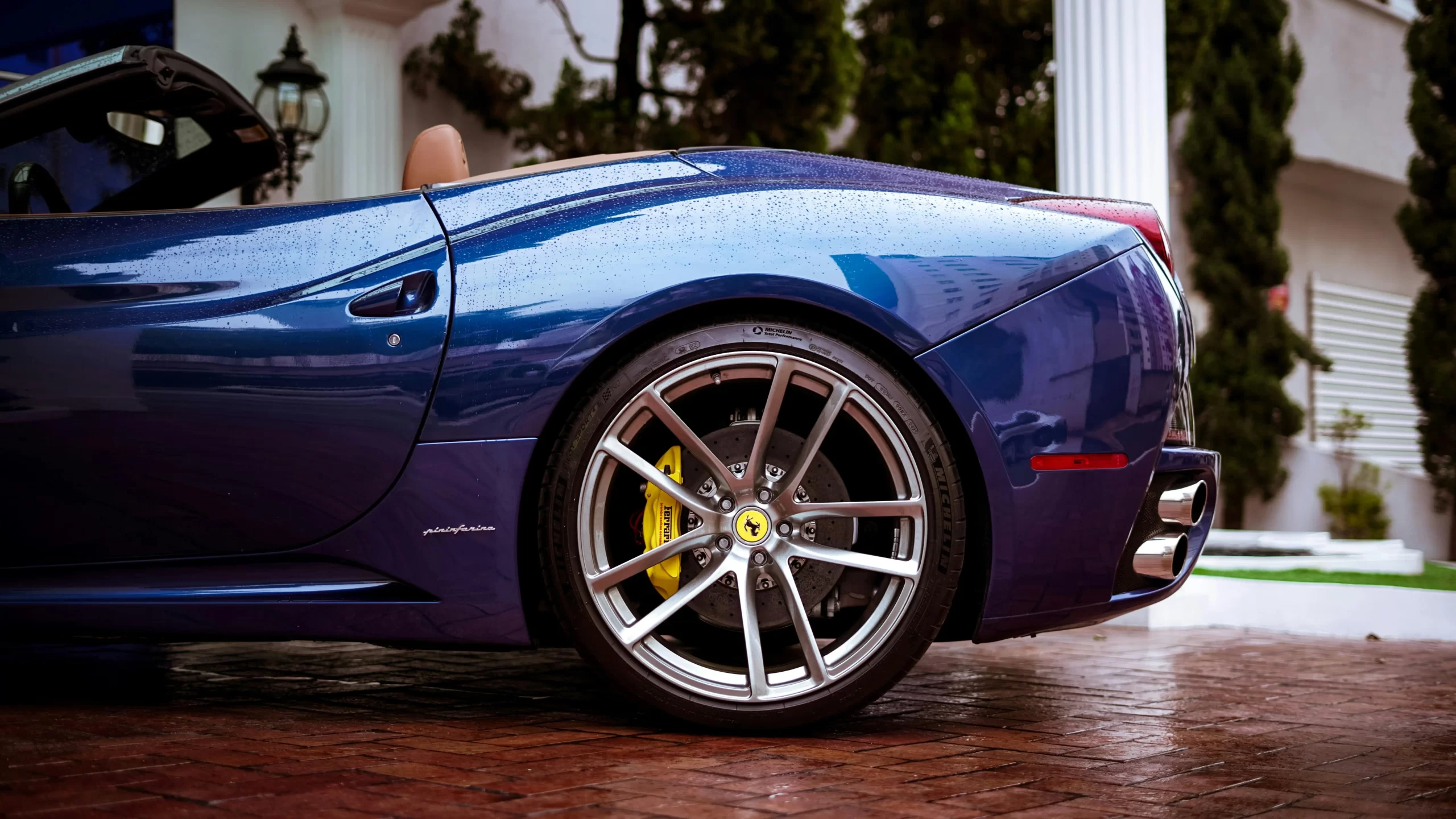 blue ferrari california with yellow brakes and brown leather seats